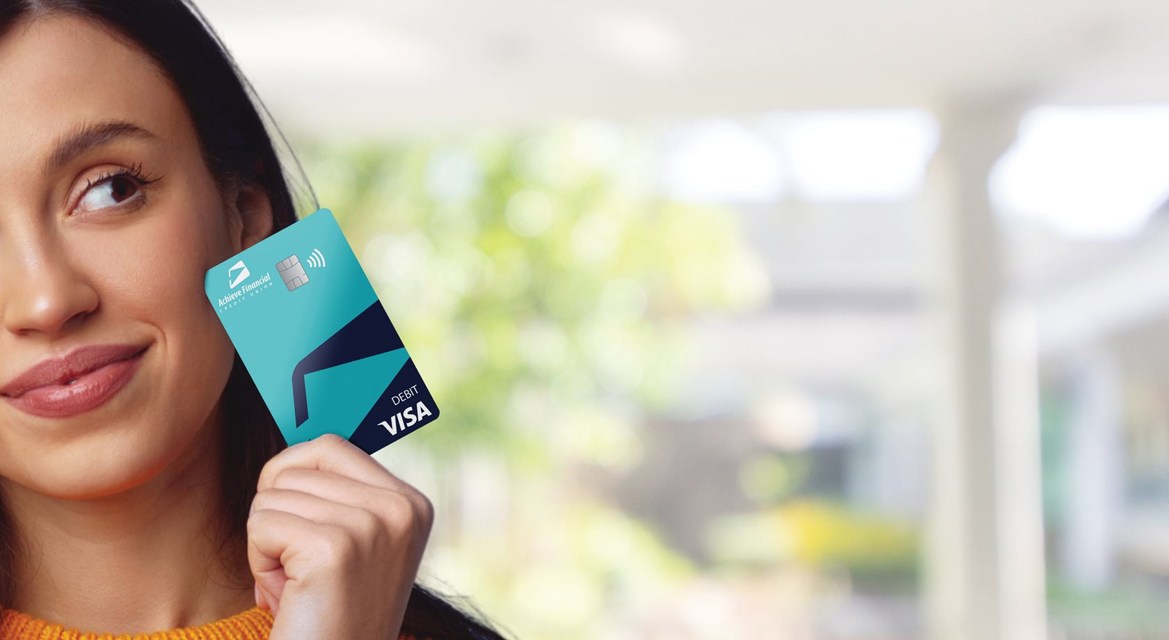 Woman holding the new Achieve Visa Debit Card