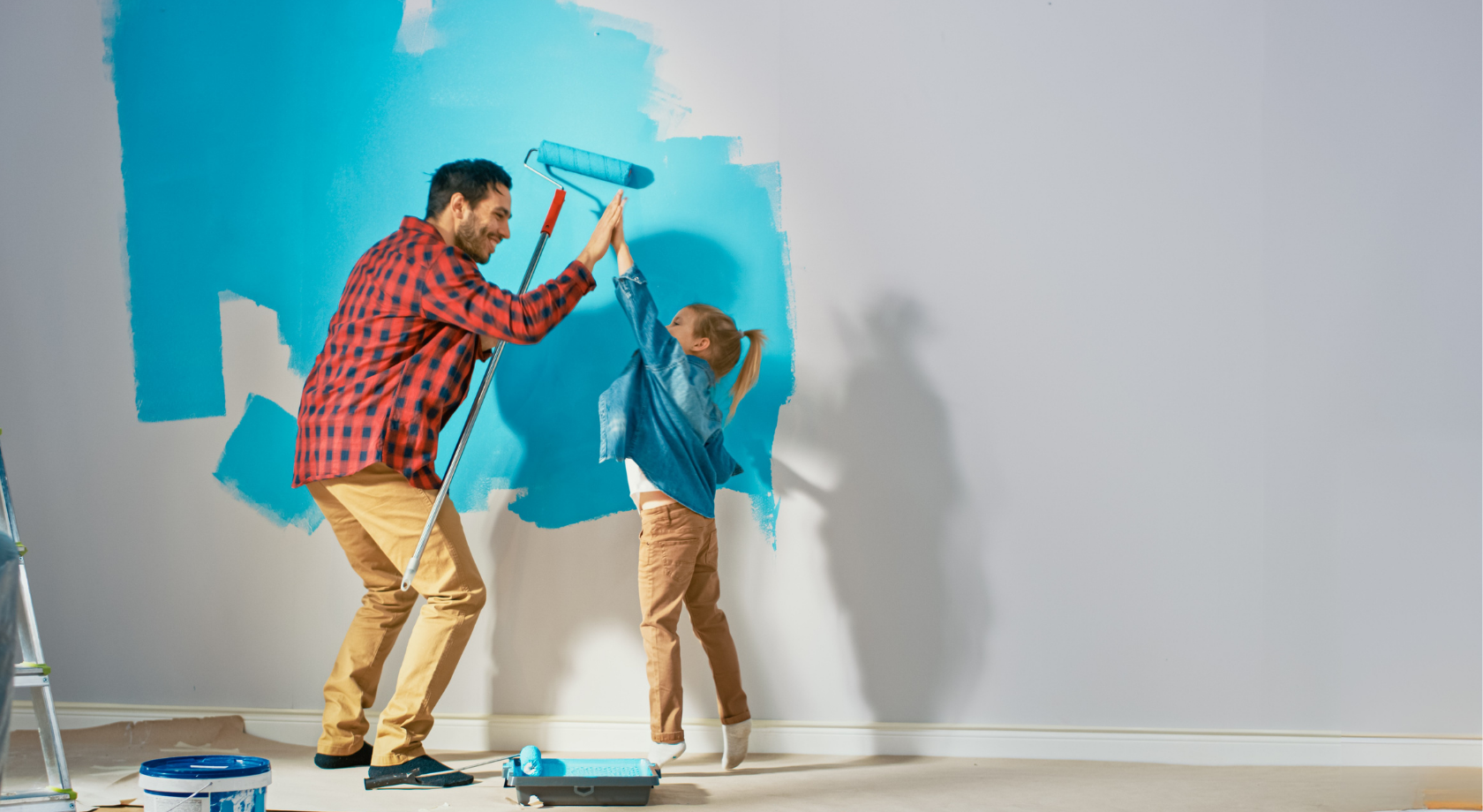 Father and daughter painting a wall together representing home improvement using home equity
